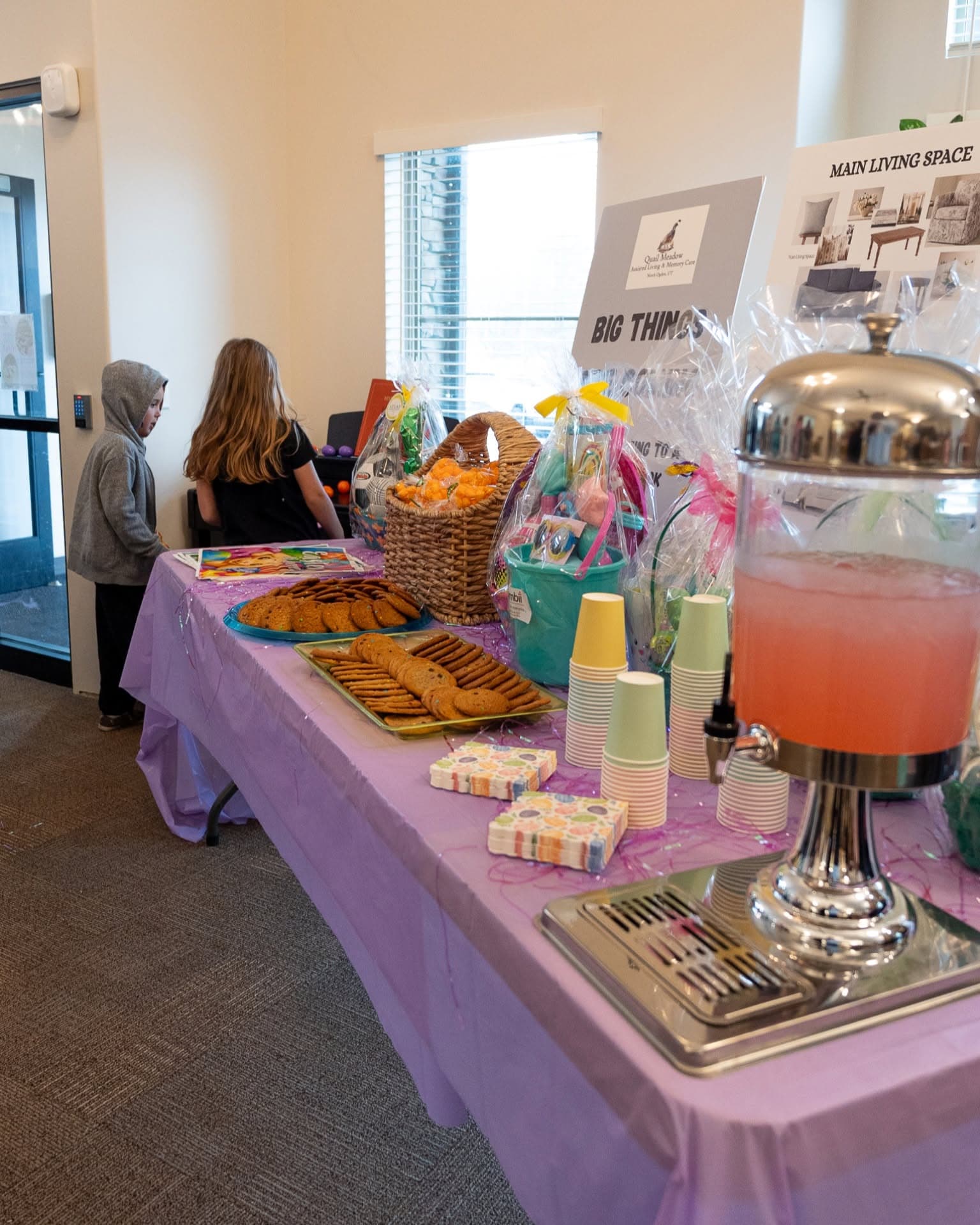 Snack table with cookies, punch, and wrapped gift baskets set up for a family event