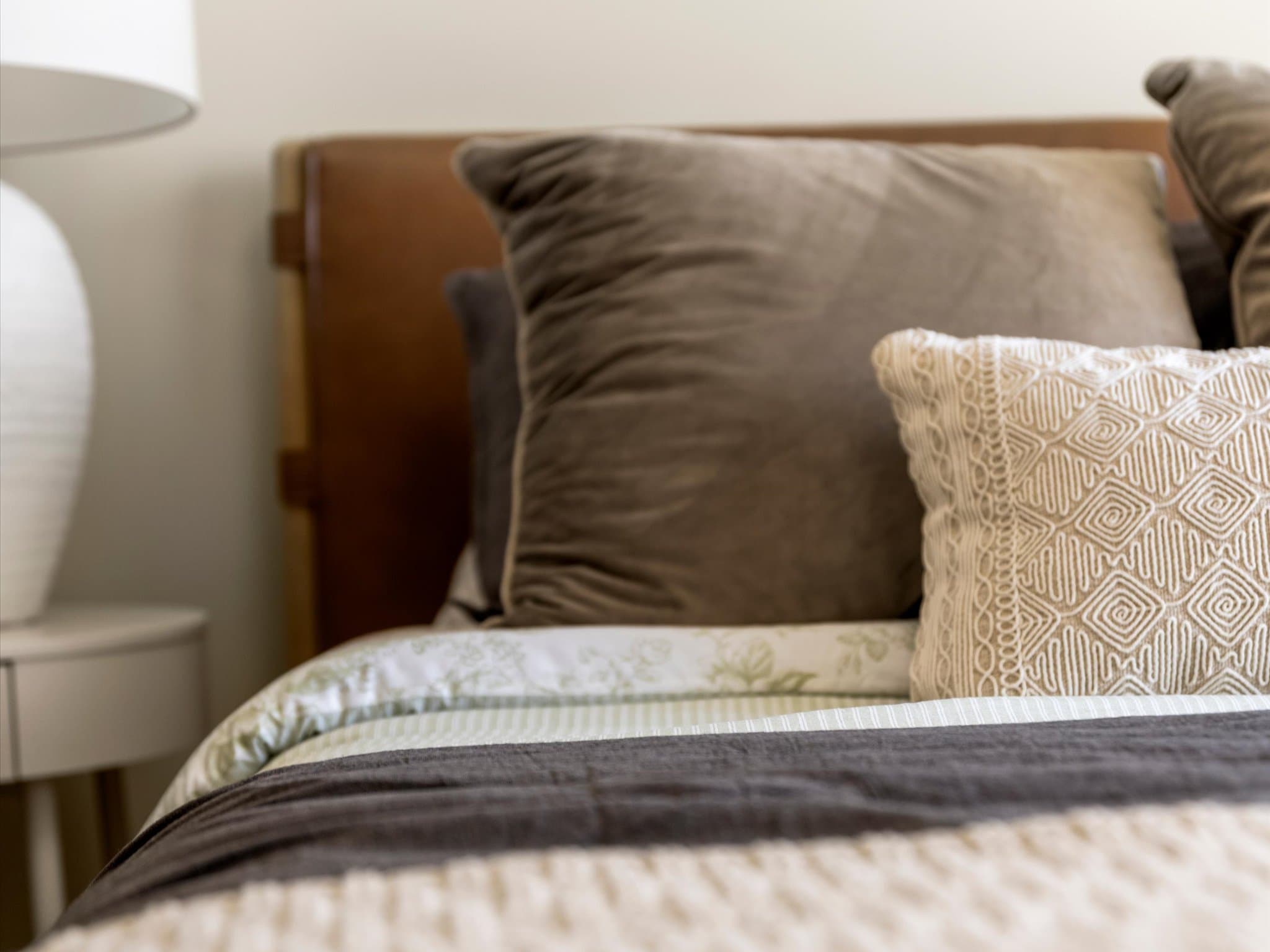 Decorative pillows and bedding on a model apartment bed