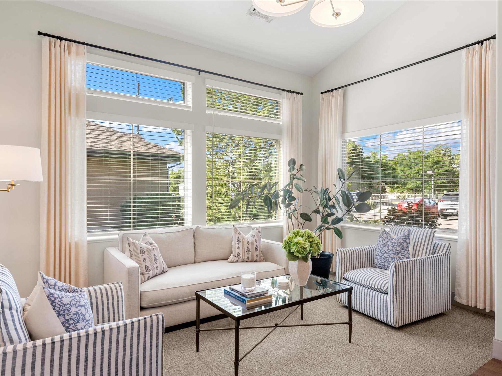 Sitting area with striped chairs and tall windows near the entrance