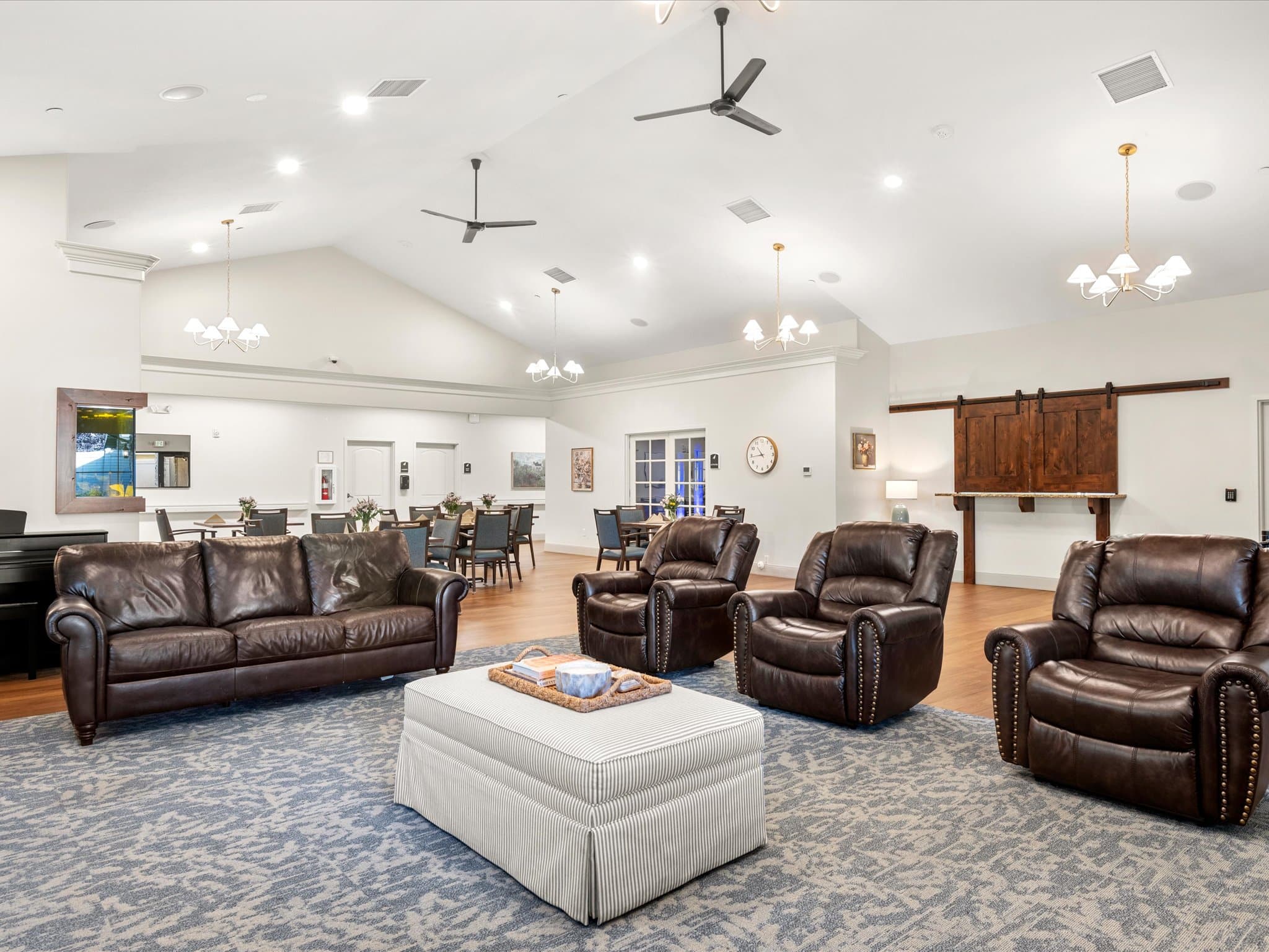Memory care living room with leather sofas, recliners, and a piano