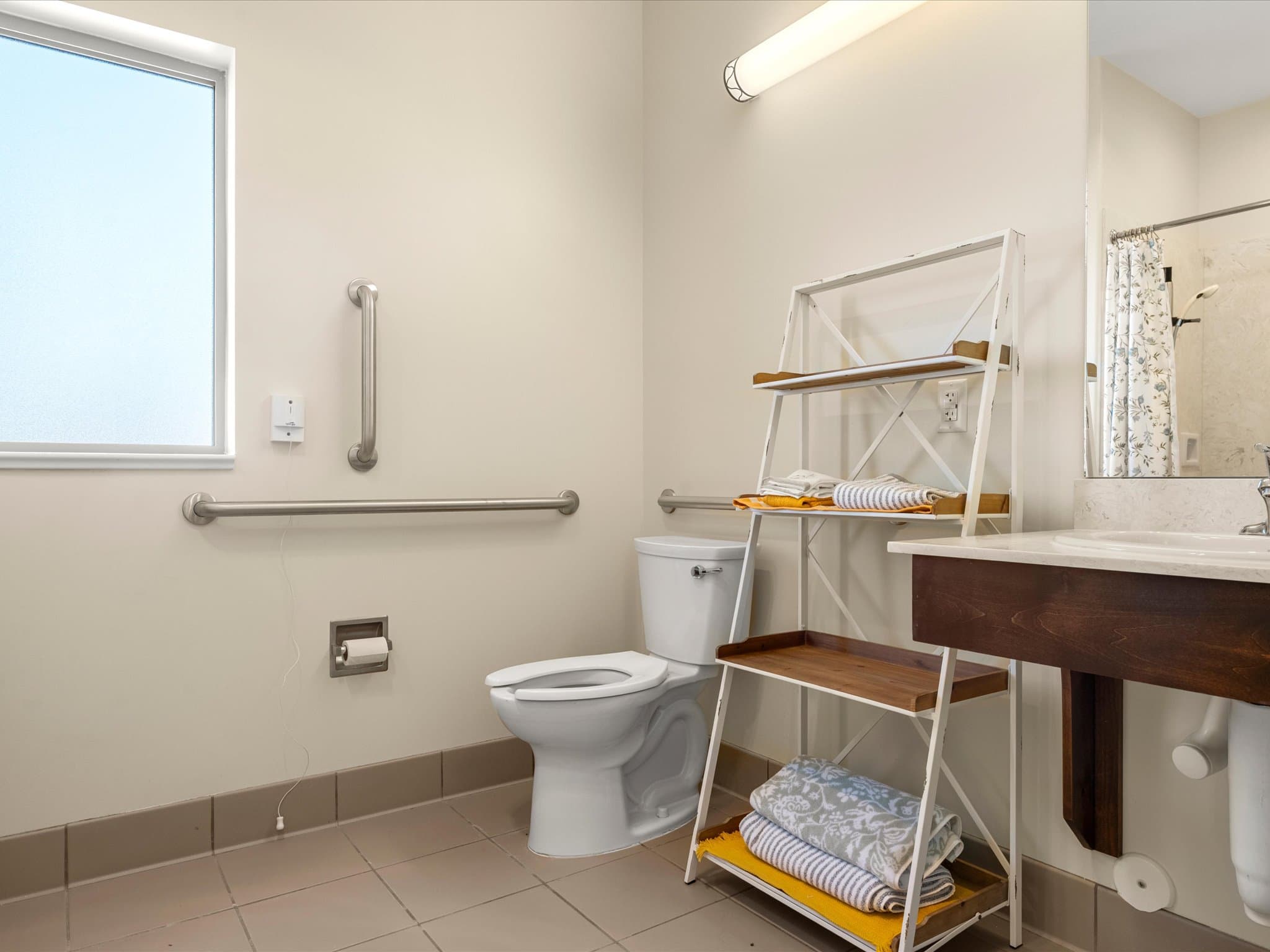Model apartment bathroom with grab bars and a vanity